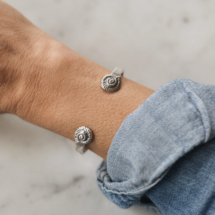 Person Wears a Sterling Silver Bracelet with Spiral Snail Shell Design