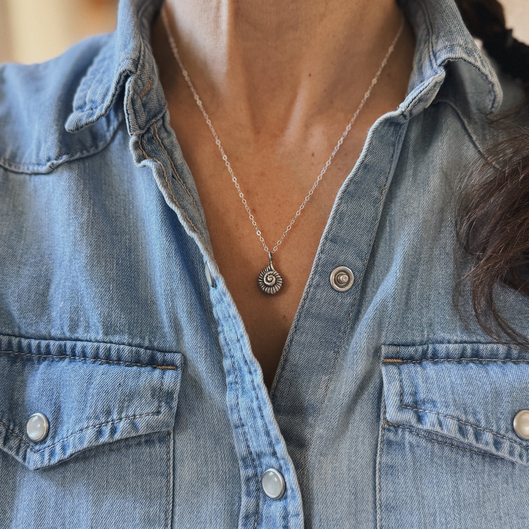 Person Wears a Sterling Silver Snail Shell Necklace and Denim Shirt