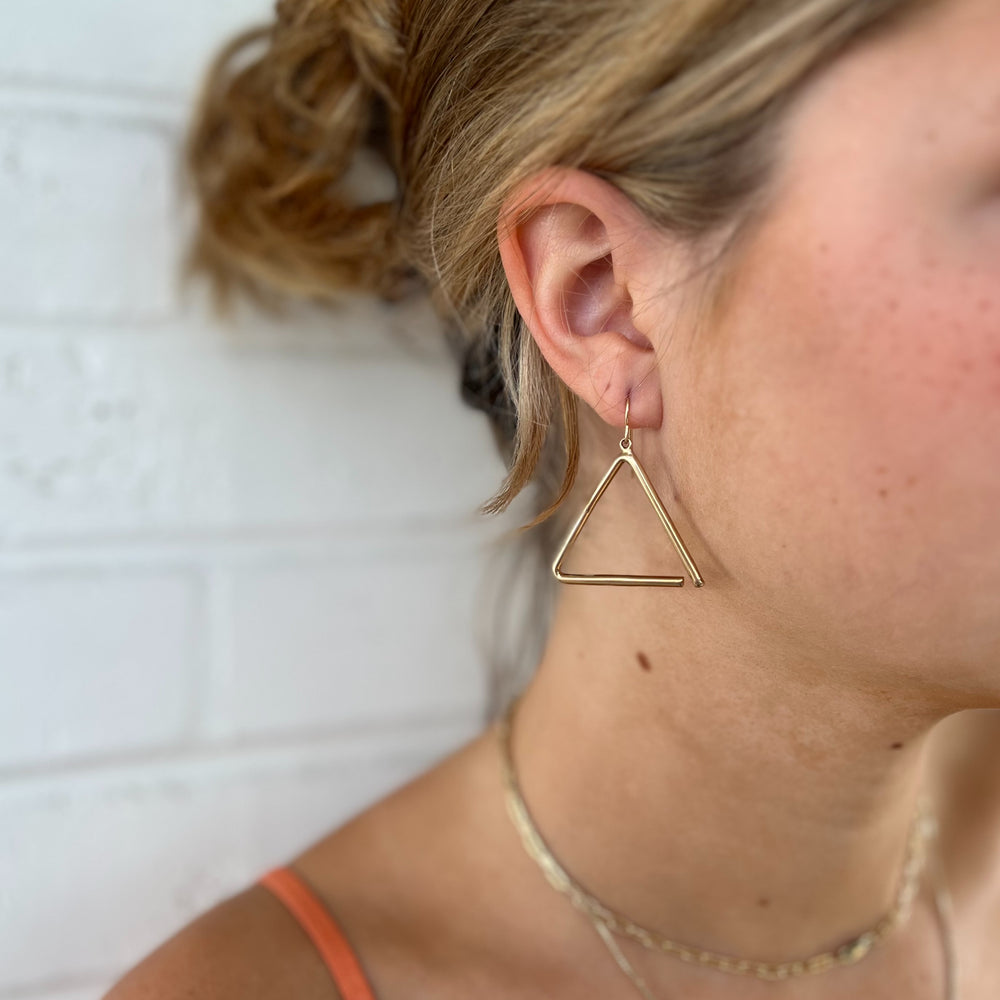 Woman Wears MIMOSA Handcrafted Triangle Earrings in Bronze.