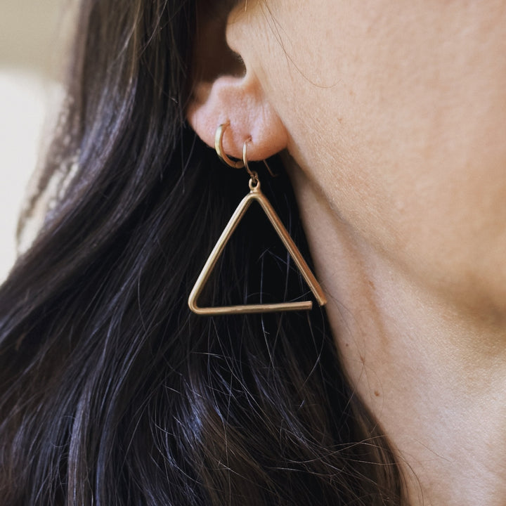 Person wears Bronze Triangle Earrings from MIMOSA Handcrafted