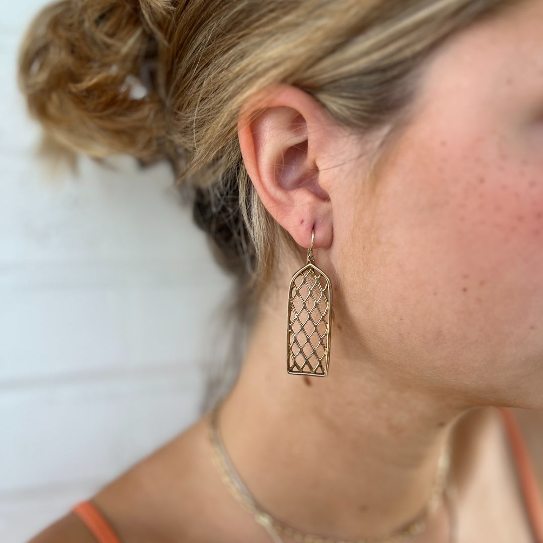 Woman Wears MIMOSA Handcrafted Window Earrings in Bronze.