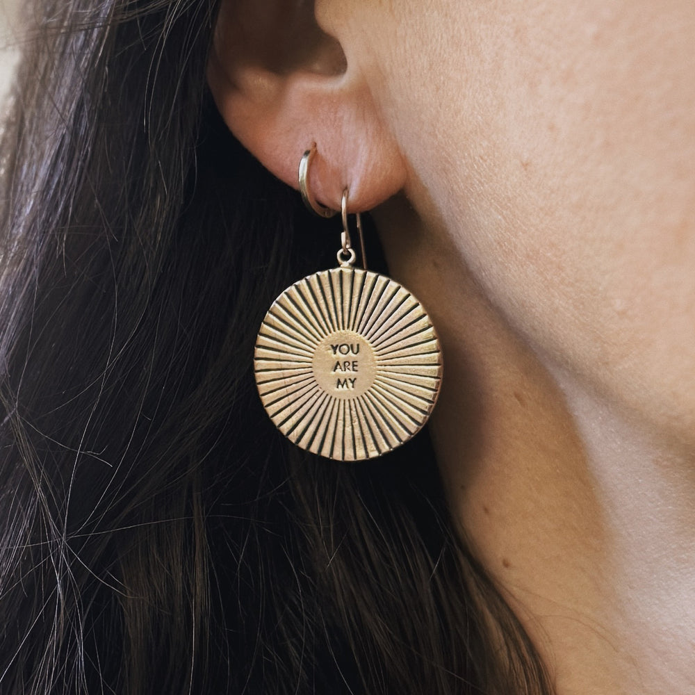 Person wears Bronze You Are My Sunshine Earrings from MIMOSA Handcrafted