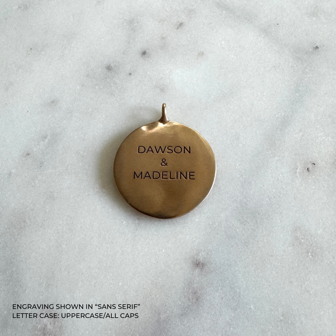 A large round bronze pendant engraved with the names &