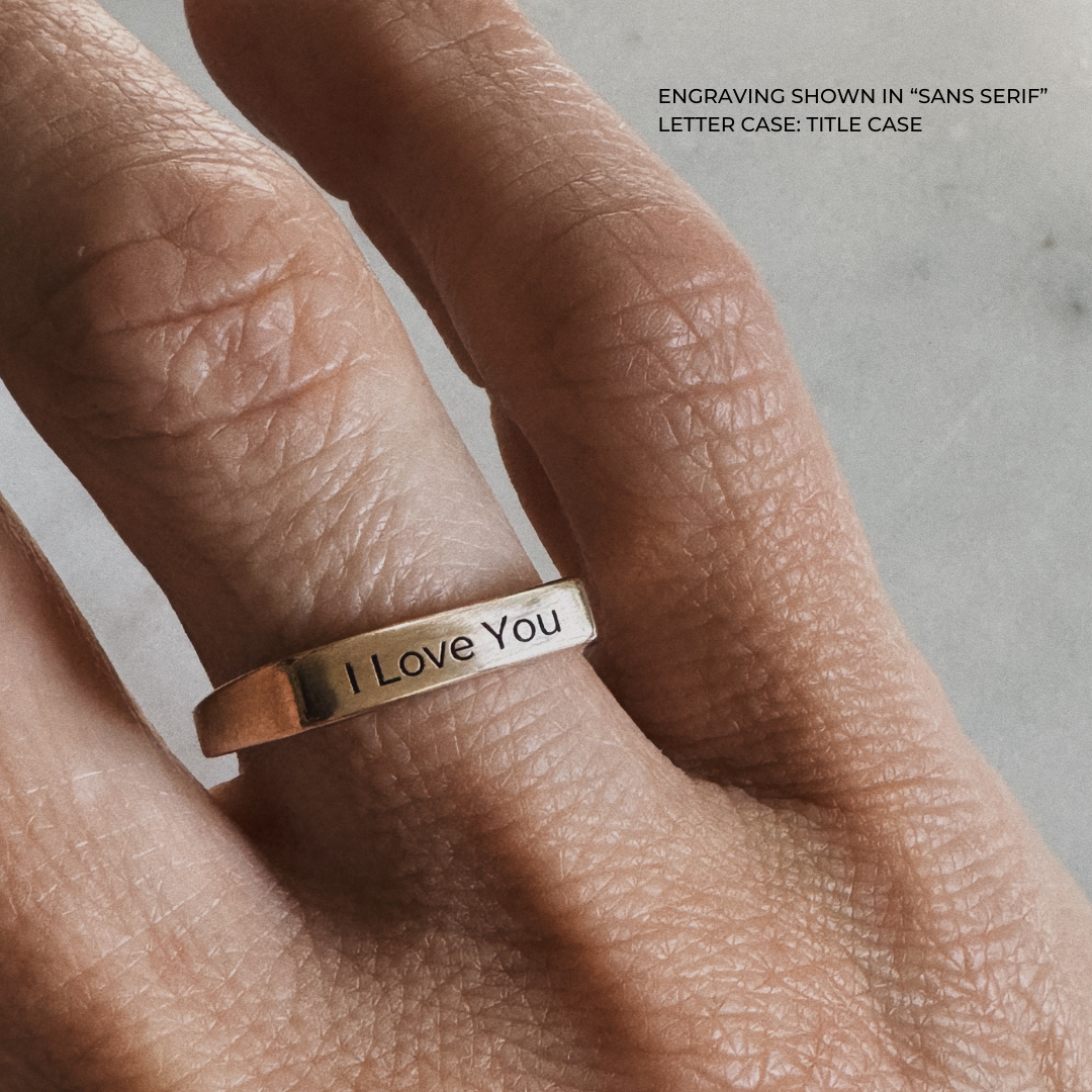 A bronze signet-style ring engraved with the words &