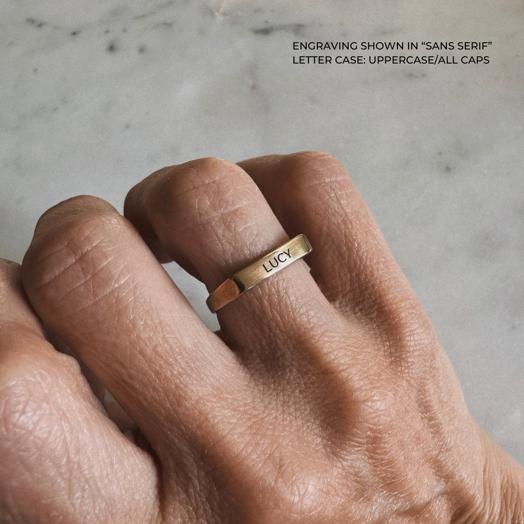 A bronze signet-style ring engraved with the name &