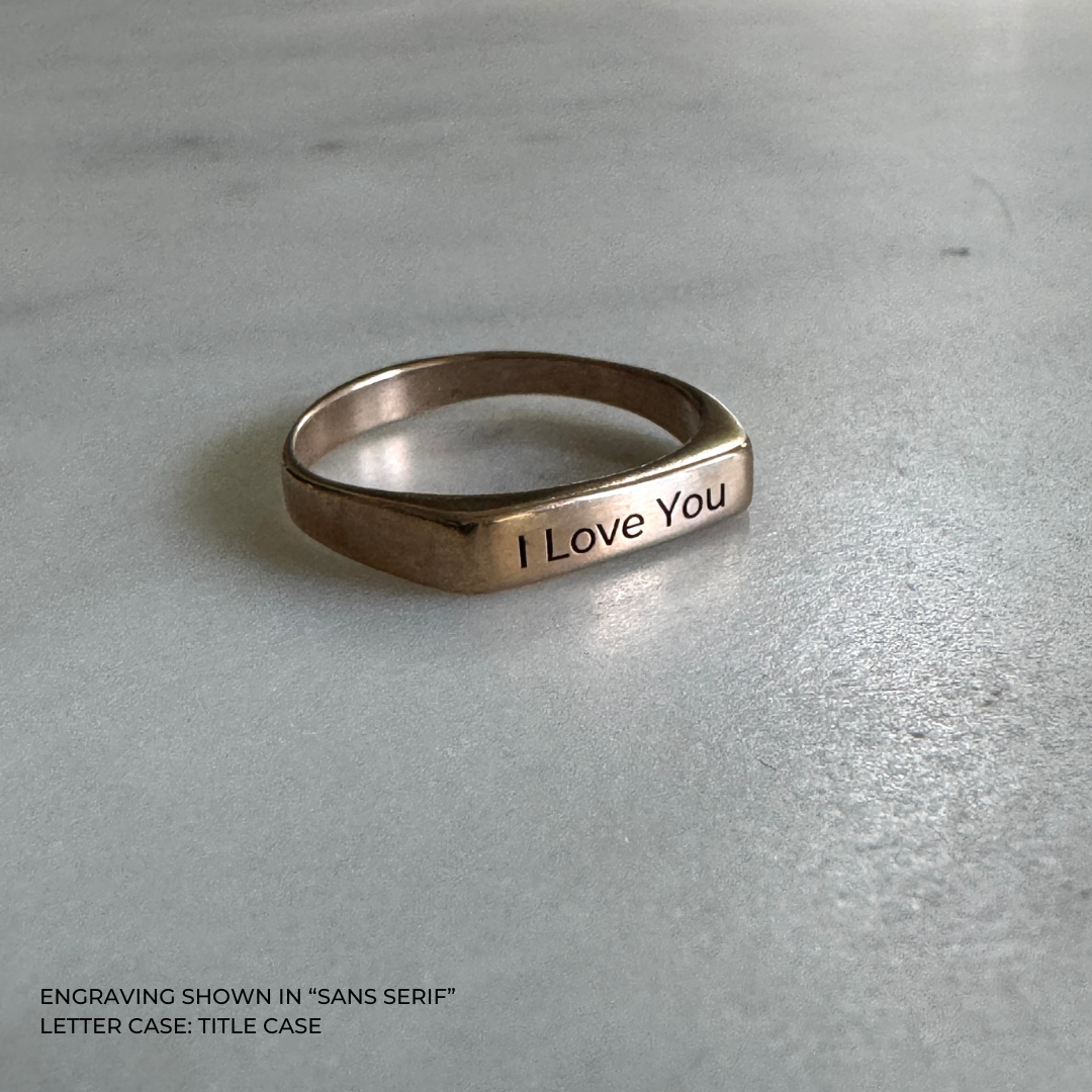 A bronze signet-style ring engraved with the words &