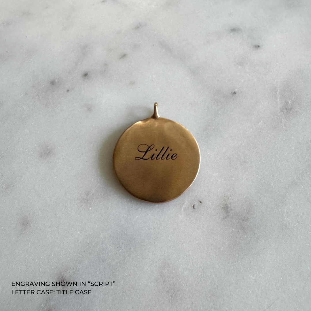 A large round bronze pendant engraved with the name &