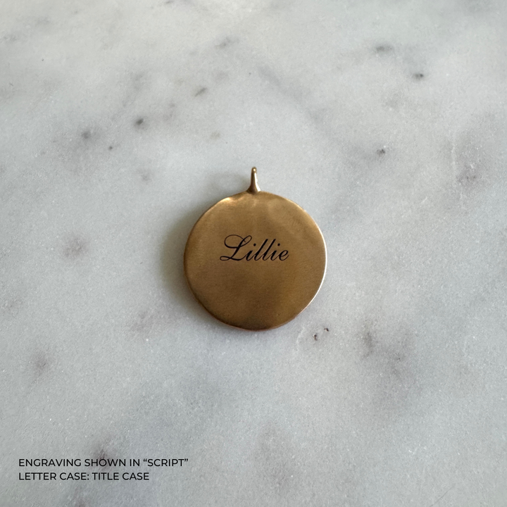 A large round bronze pendant engraved with the name &