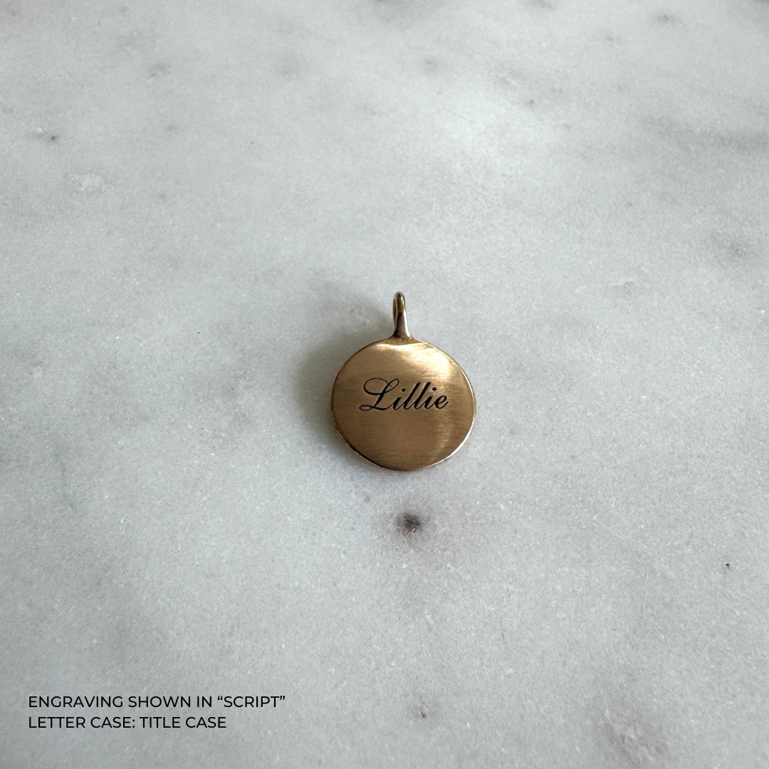 A small round bronze pendant engraved with the name &