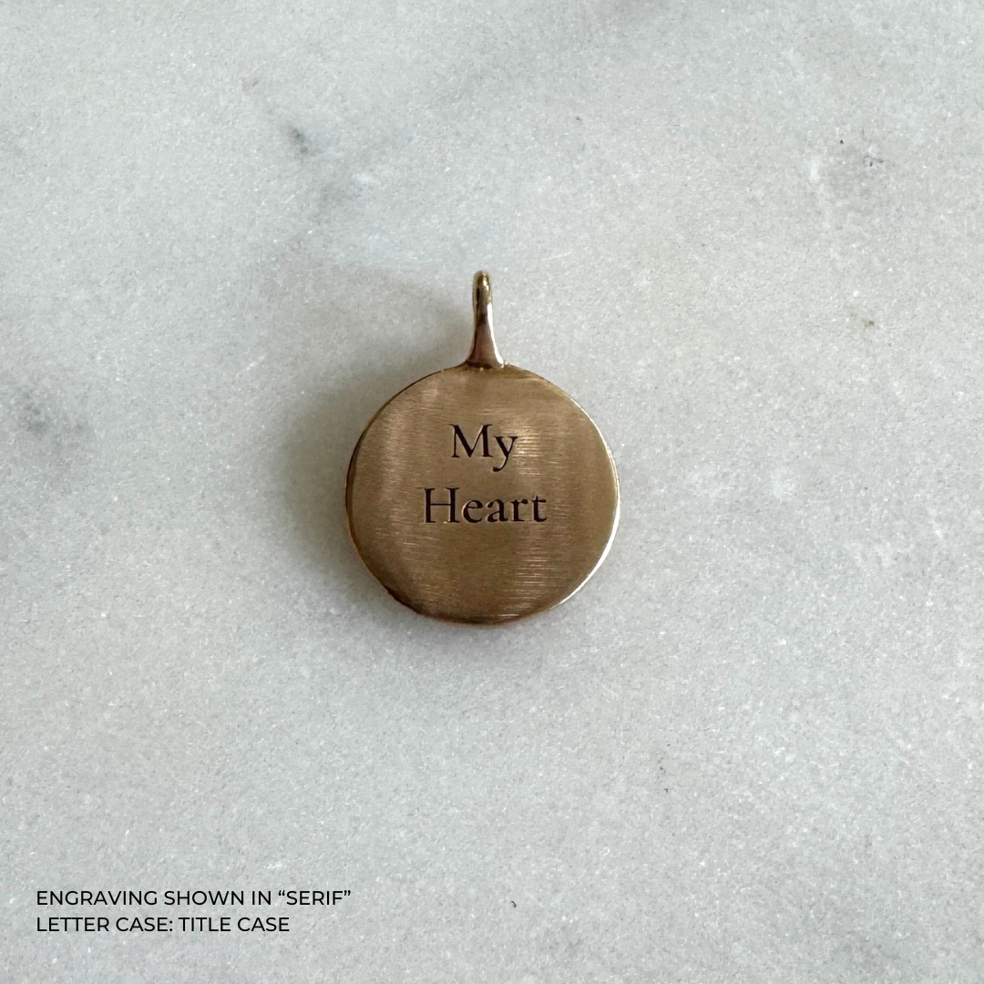 A round bronze pendant engraved with the words &