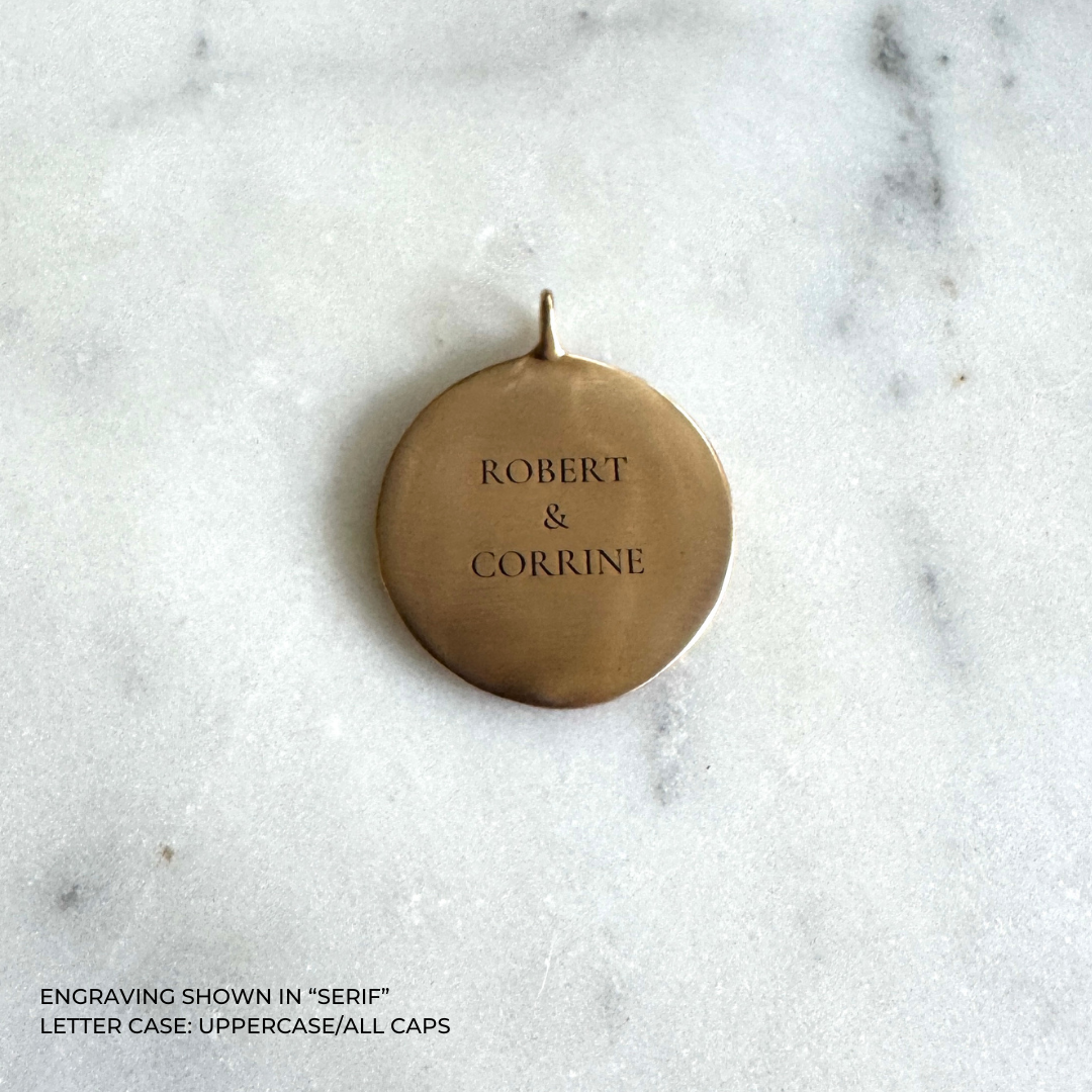 A large round bronze pendant engraved with the names &