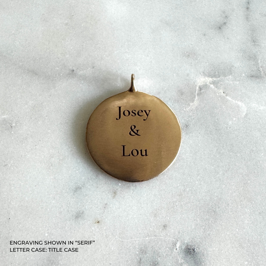 A large round bronze pendant engraved with the names &