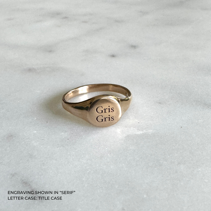 A bronze signet-style ring engraved with the words &