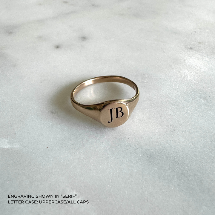 A bronze signet ring with the initials &