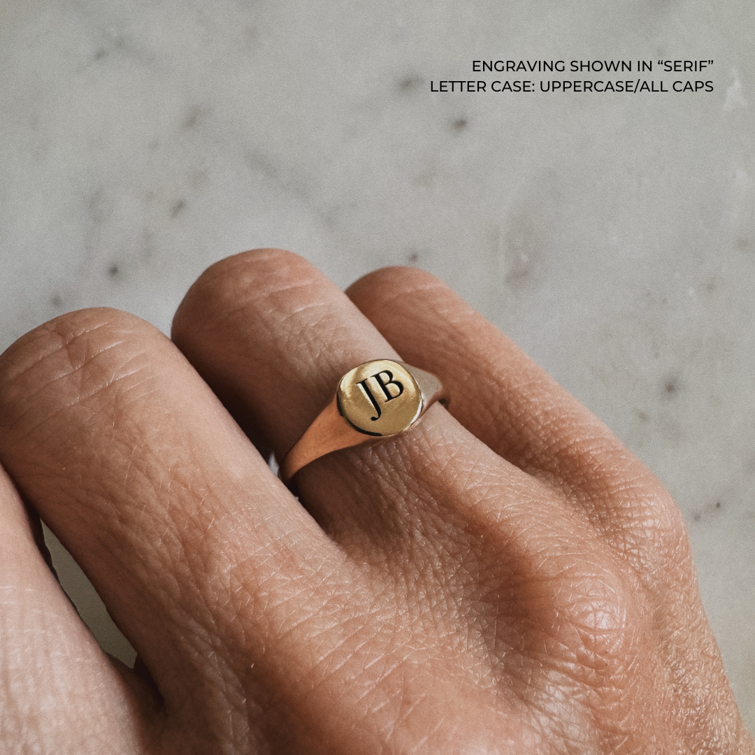 A bronze signet ring with the initials &