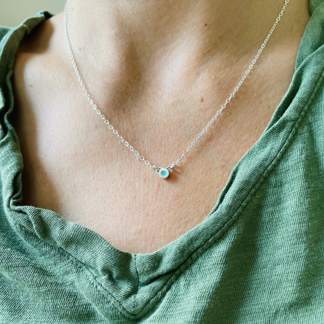 Handmade Sterling Silver Birthstone Necklace with Turquoise on Person Wearing a Green Top