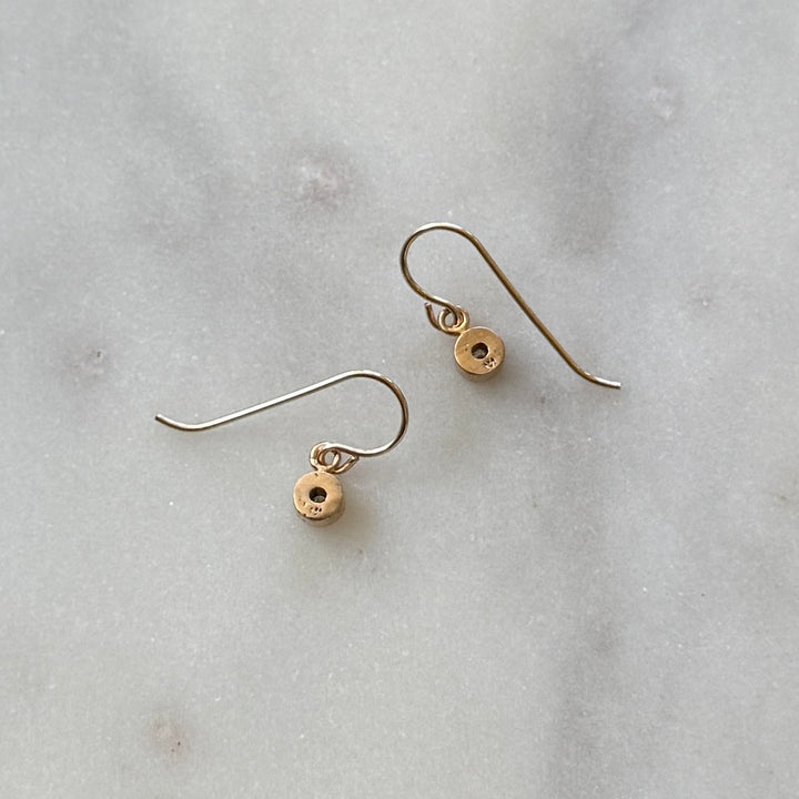 Pair of bronze grace birthstone earrings on a light gray marble surface | MIMOSA Handcrafted