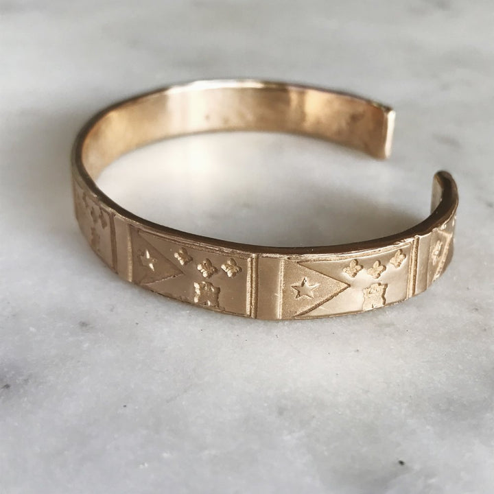 Side View of Handmade Bronze Bracelet Stamped with Acadian Flags