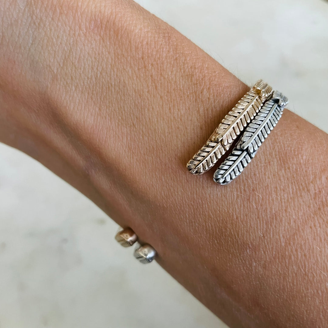 Woman Wearing Handmade Bronze and Silver Mimosa Sprig Cuff Bracelets