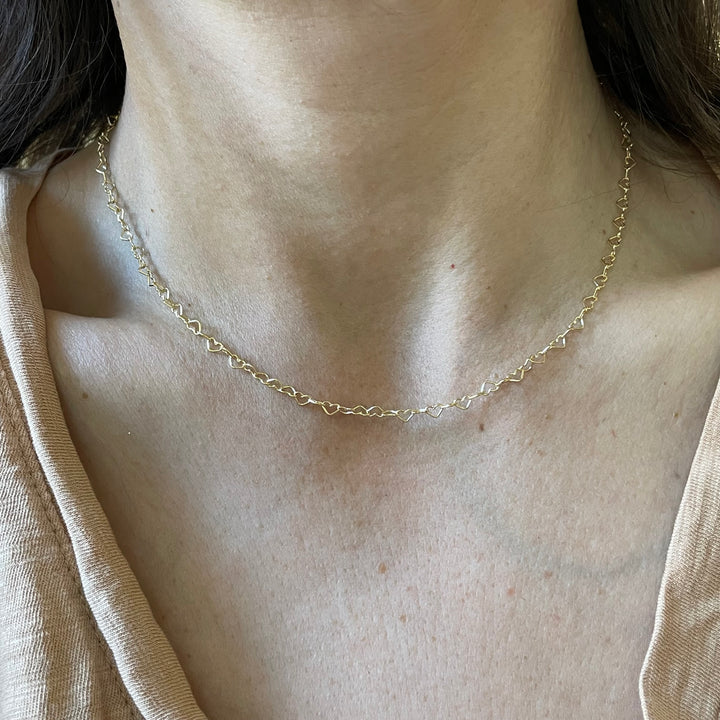 Madeline Wears MIMOSA Handcrafted's Dainty Gold-Filled Heart Chain Featuring Heart-Shaped Links.