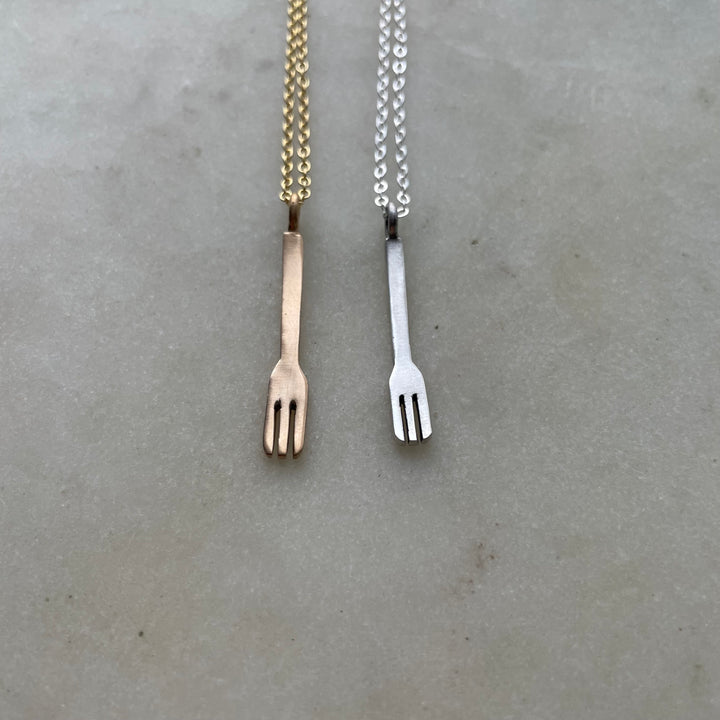 Small Handcrafted Bronze And Silver Fork Pendants Shown Side By Side